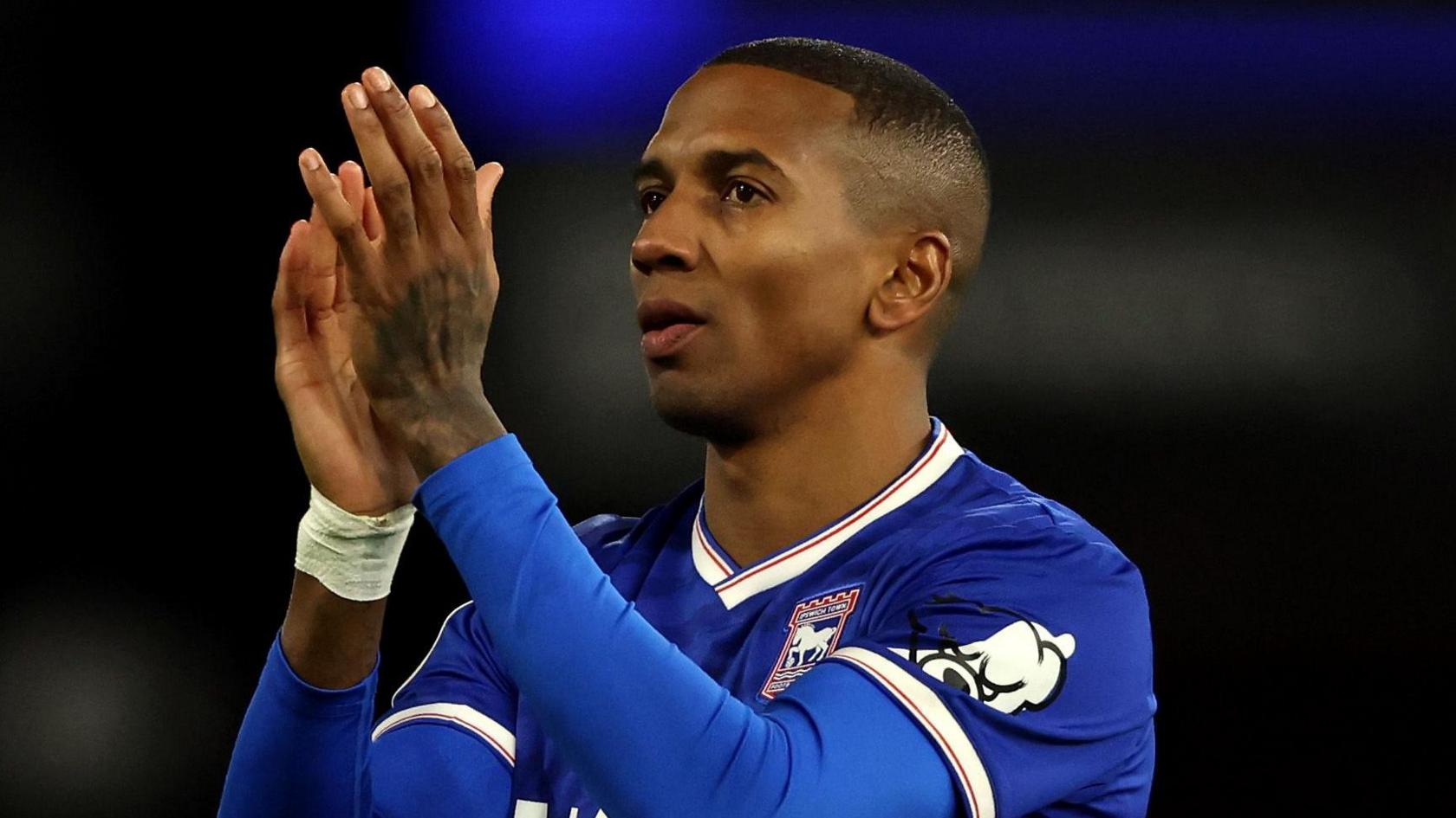 Former England defender Ashley Young in a blue Ipswich Town shirt, clapping his hands