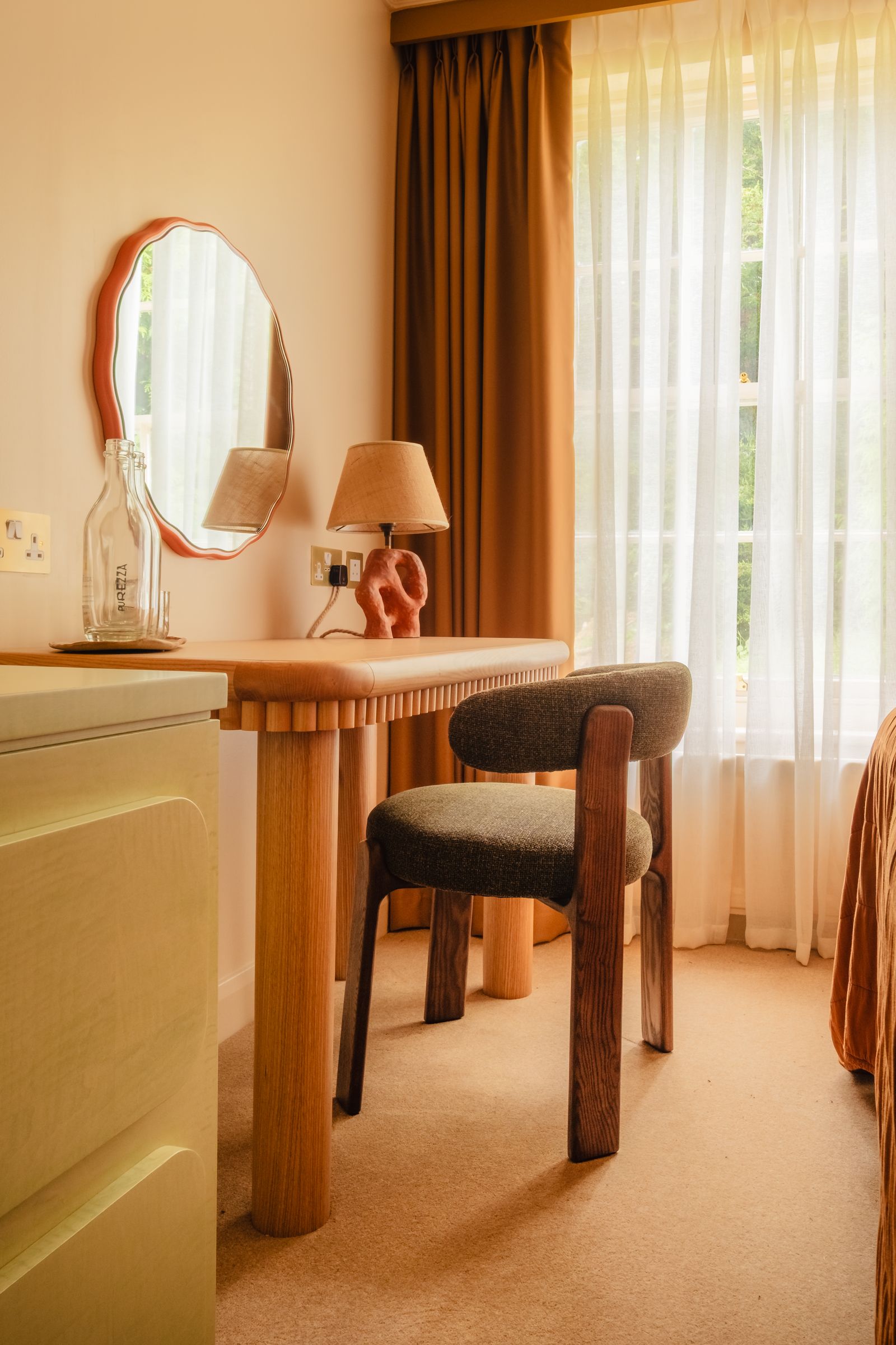 Image may contain Lamp Indoors Interior Design Chair Furniture Wood Table Lamp Desk Table and Window