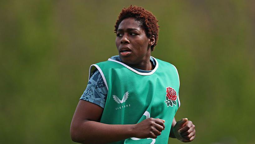 Christiana Balogun jogging and wearing training kit and a Red Roses branded vest during a training session for England during the Six Nations