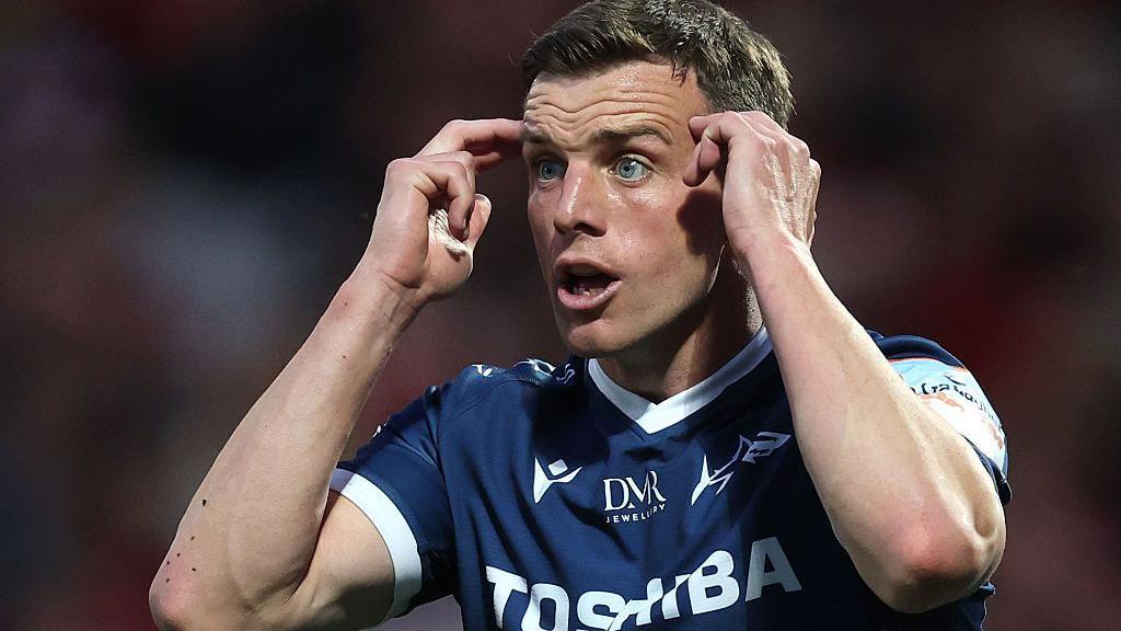 Sale Sharks' George Ford gestures by touching his fingers to his temples during a match