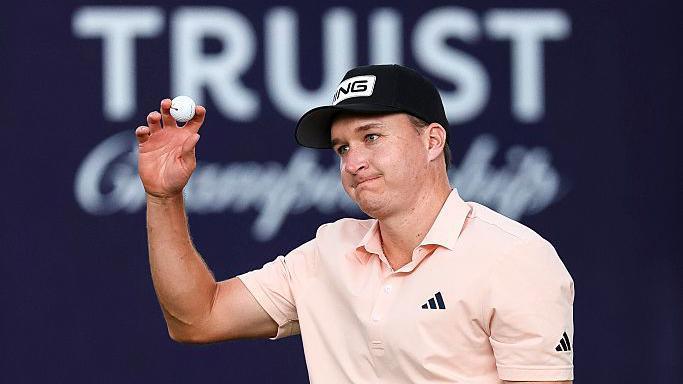 Matt McCarty holds up his ball to salute the crowd after making a putt during the first round of the Truist Championship in 2026