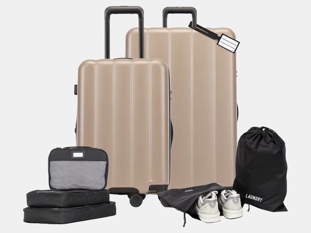 two tan suitcases with smaller black packing accessories
