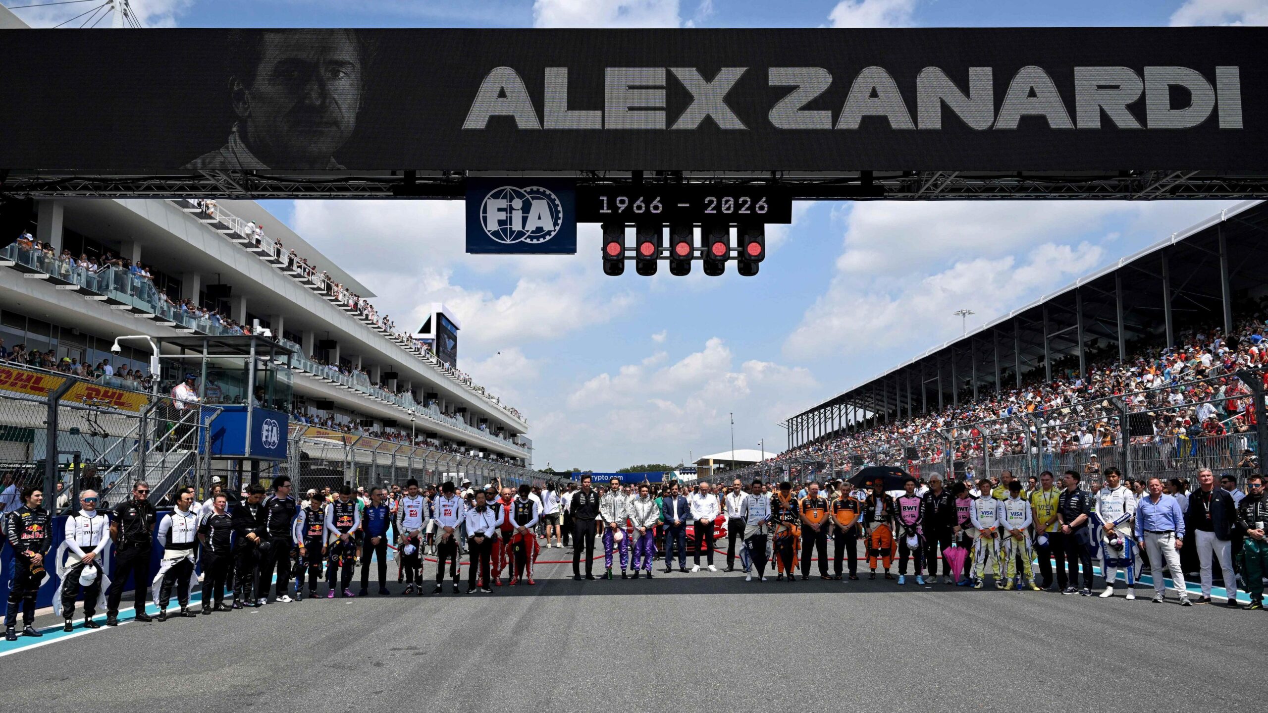 Drivers and team members gather on the grid for a minute's silence to pay tribute to Alex Zanardi, the former F1 driver, IndyCar champion and Paralympic champion who died on Friday, aged 59. Zanardi's image is visible on the electronic screen above the start-finish straight