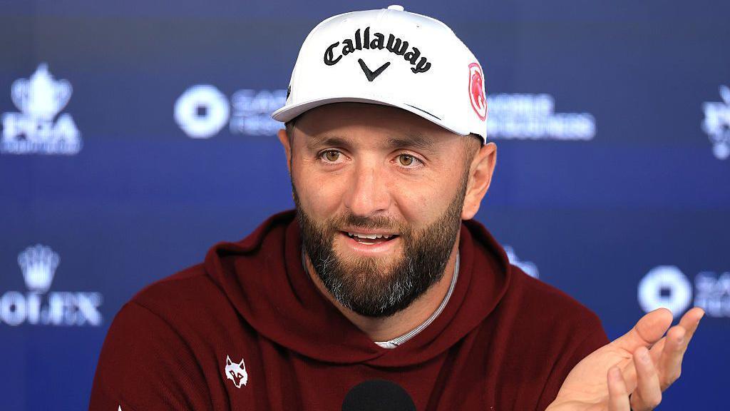 Jon Rahm gesticulates during a PGA news conference