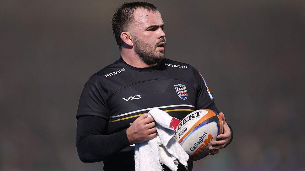 Newcastle's George McGuigan uses a towel to wipe down a rugby ball