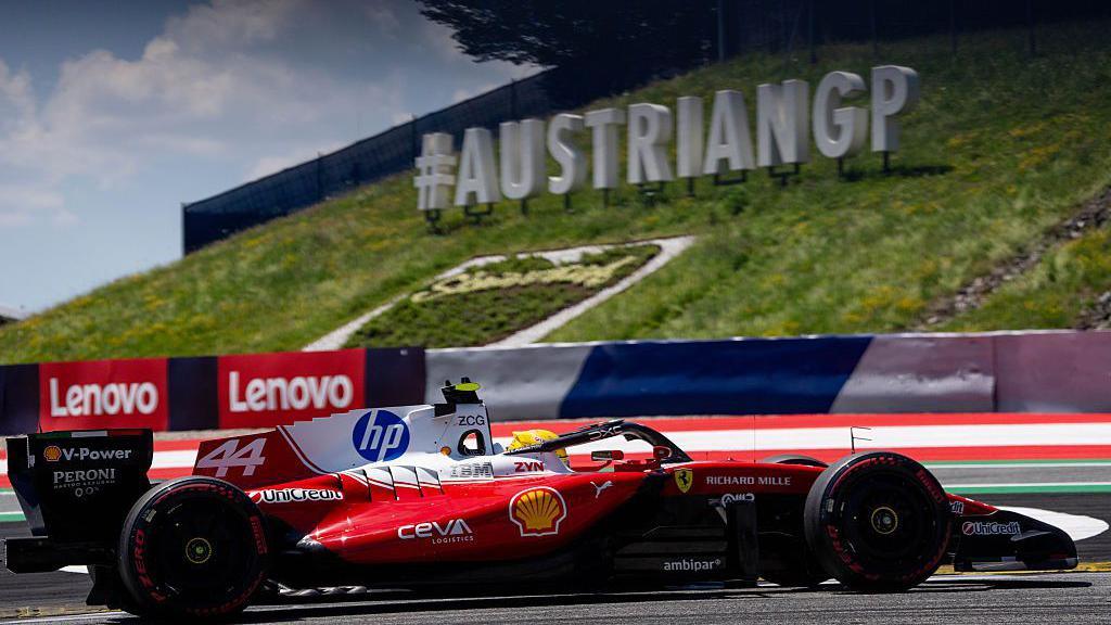 Lewis Hamilton drives past a AustrianGP sign on track in Spielberg