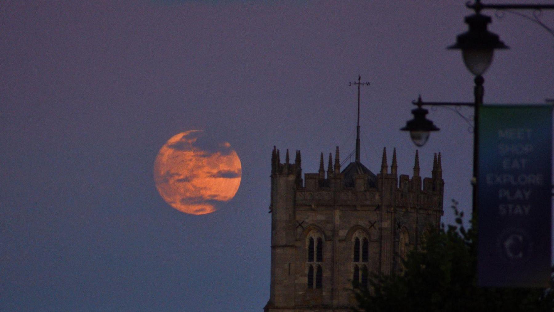 Strawberry Moon rising beside Christchurch Priory