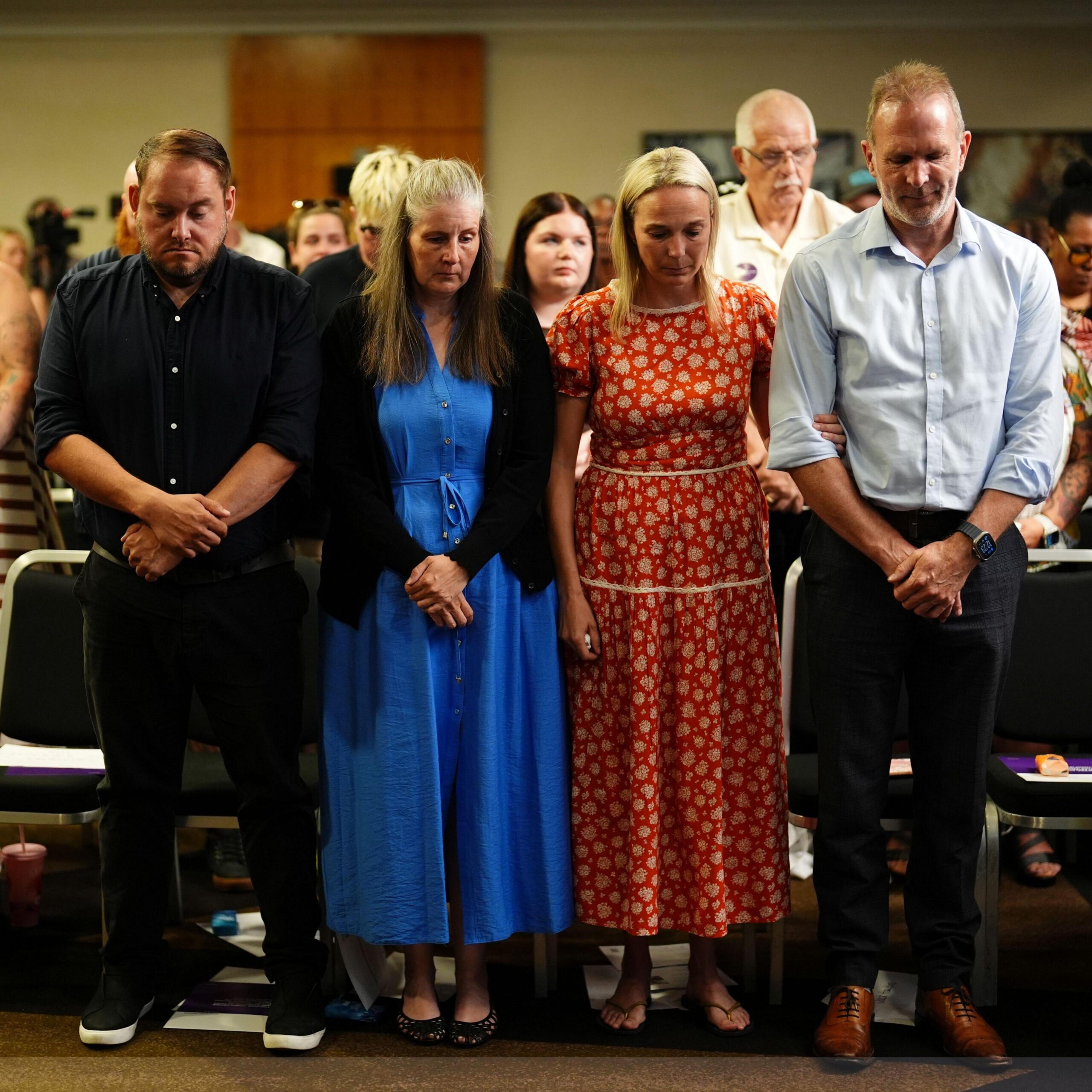 Four people - Gary Andrews, Sarah Andrews, Sarah Hawkins and Jack Hawkins - stand side by side. Gary is dressed in a black shirt and black trousers, Sarah wears a long blue dress with a dark cardigan, Sarah wears a long red dress with white detail and Jack wears a light blue shirt with dark trousers.