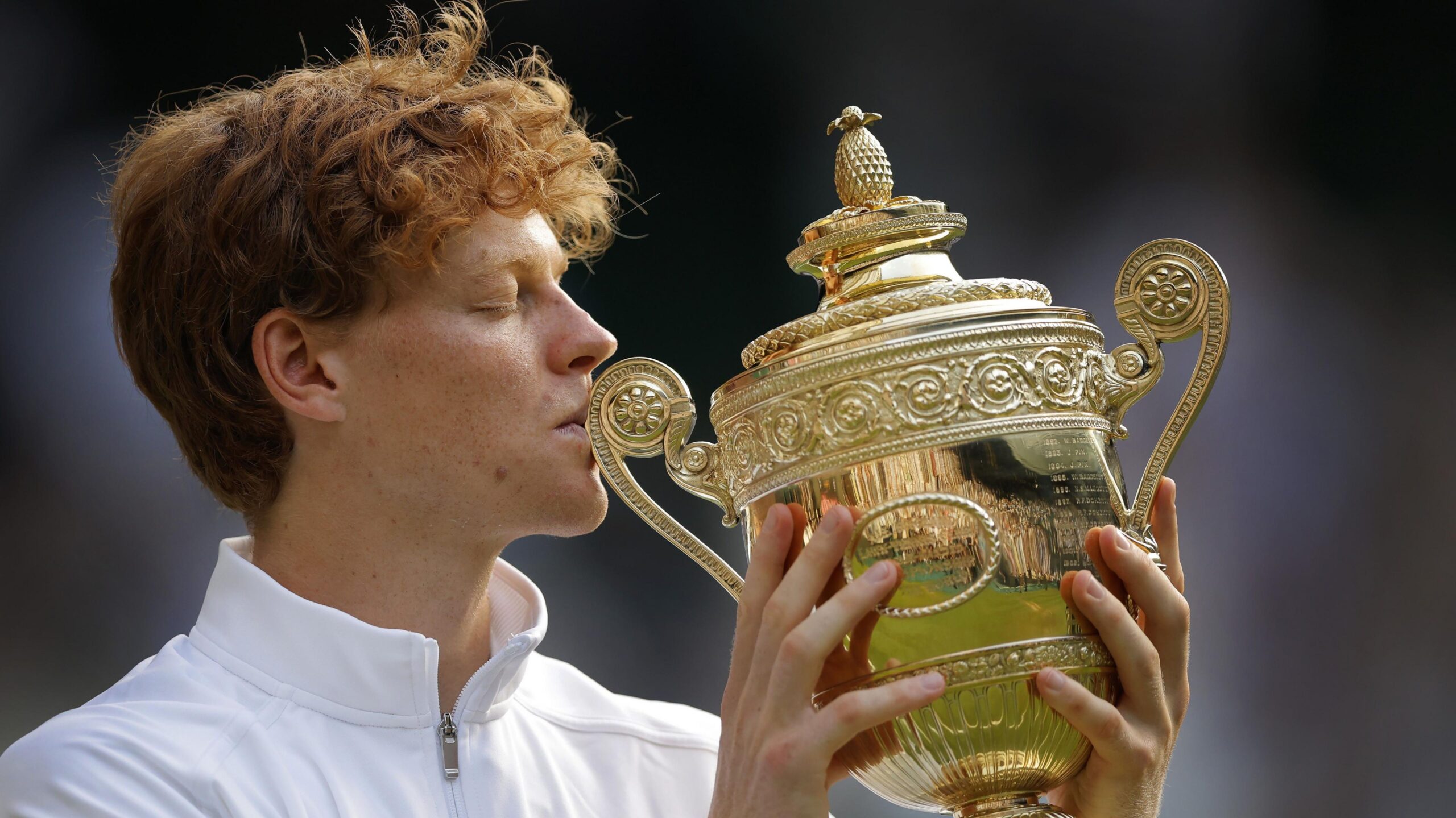 Jannik Sinner kisses the Wimbledon trophy