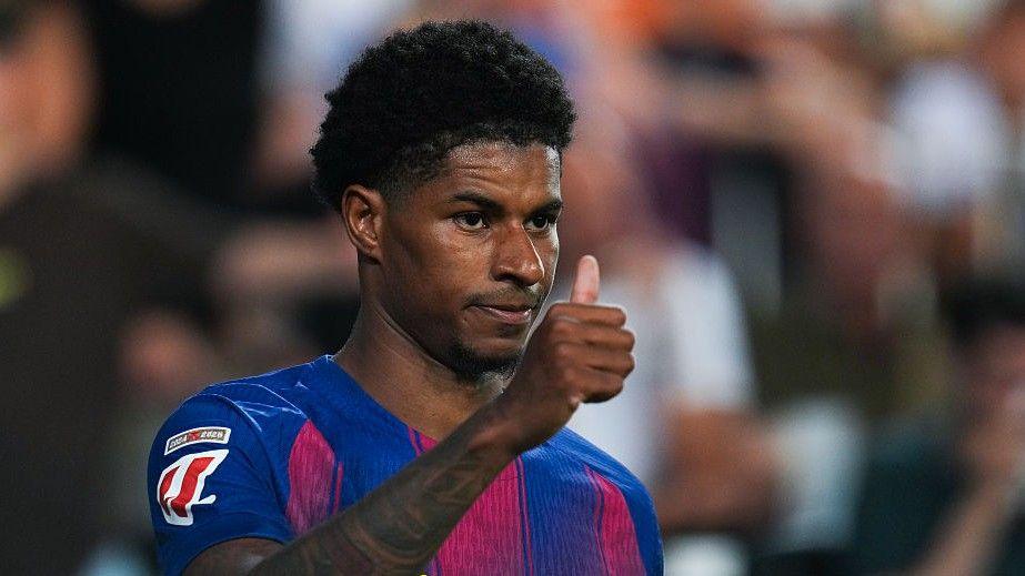 Marcus Rashford gives a thumbs-up gesture while wearing Barcelona's home kit