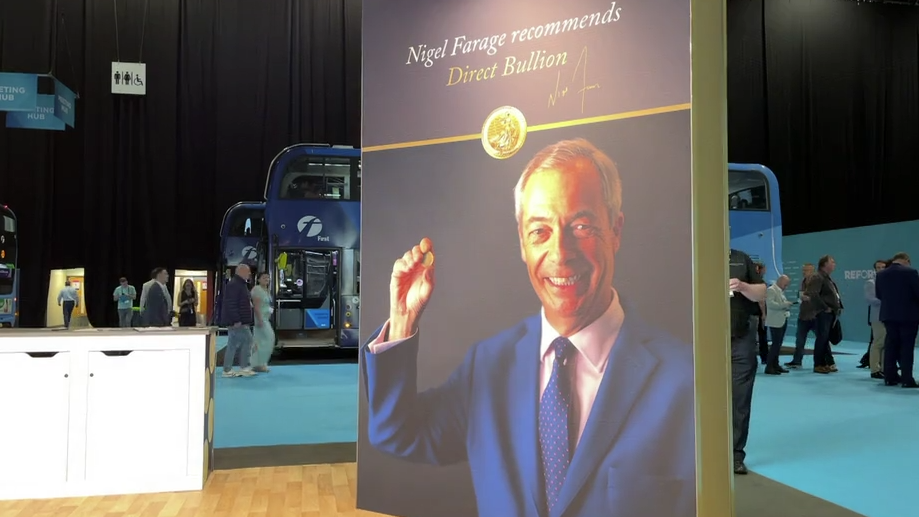 A large poster depicts Nigel Farage holding a gold coin and smiling. Above him there is a tagline that reads: "Nigel Farage recommends Direct Bullion". An image of his signature is underneath.