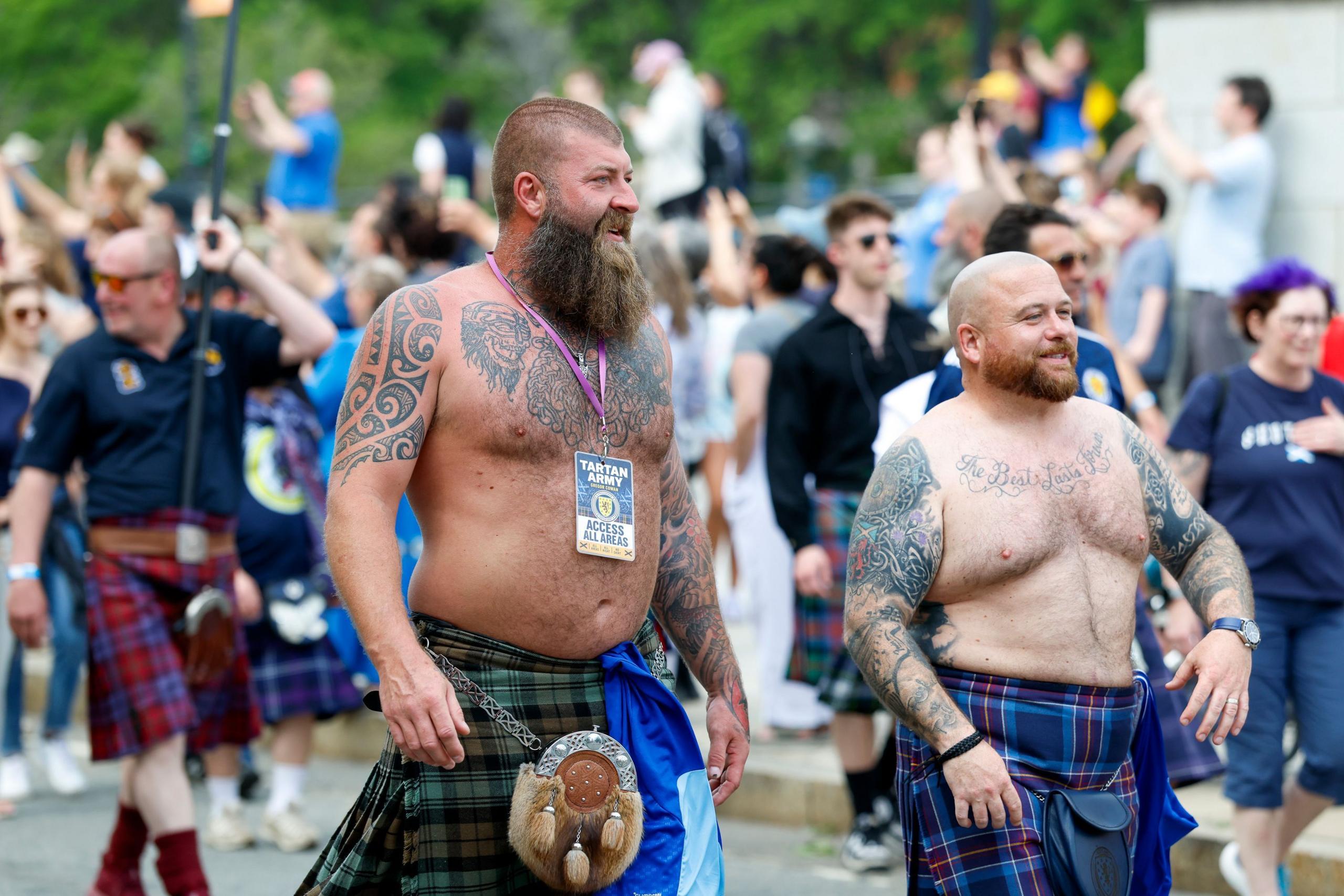 Two bare-chested members of the Tartan Army take part in a march through Boston