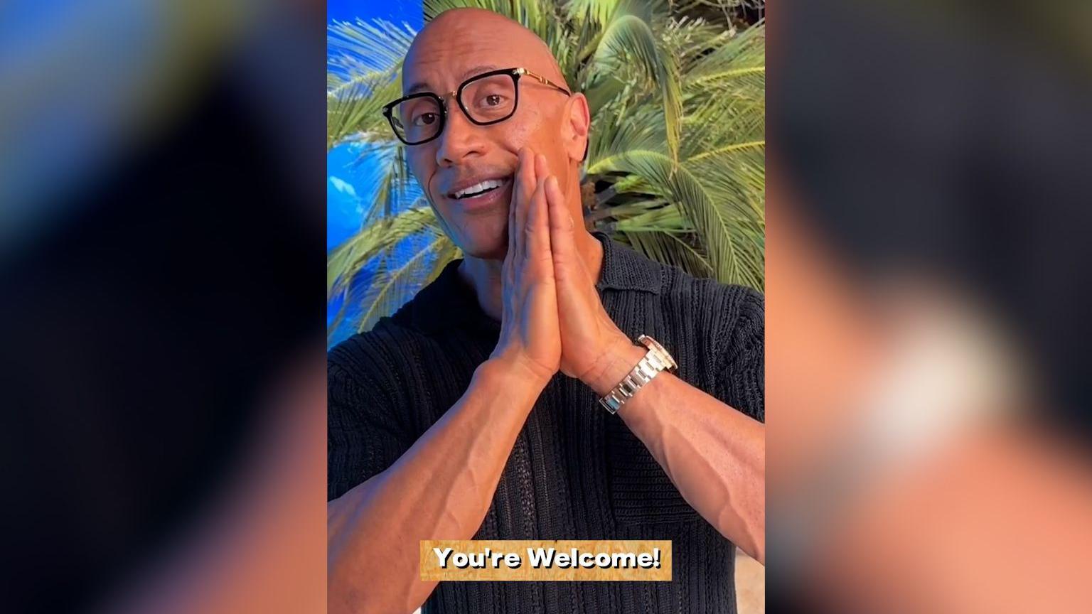 A screenshot of Dwayne Johnson's video to the students. The background is a tropical beach and the caption reads "You're welcome!"