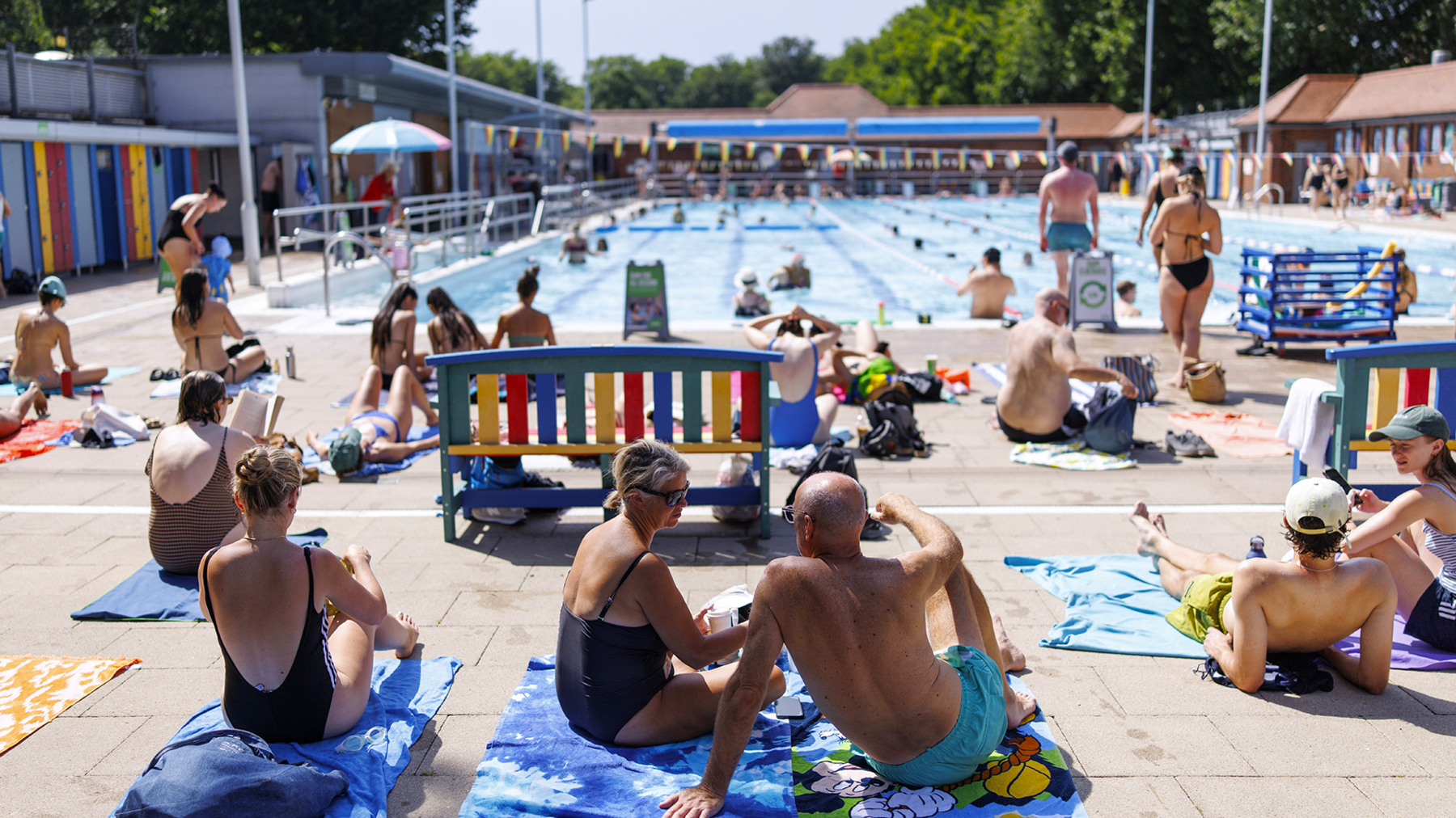 People sunbathe at London Fields Lido outdoor swimming pool as the UK is set to experience its hottest June day on record during a heatwave in London, Britain, 23 June 2026.