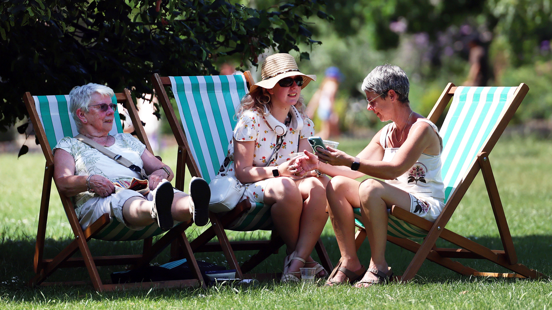 Park goers relax on deckchairs in the shade during a heatwave in London, Britain, 24 June 2026.
