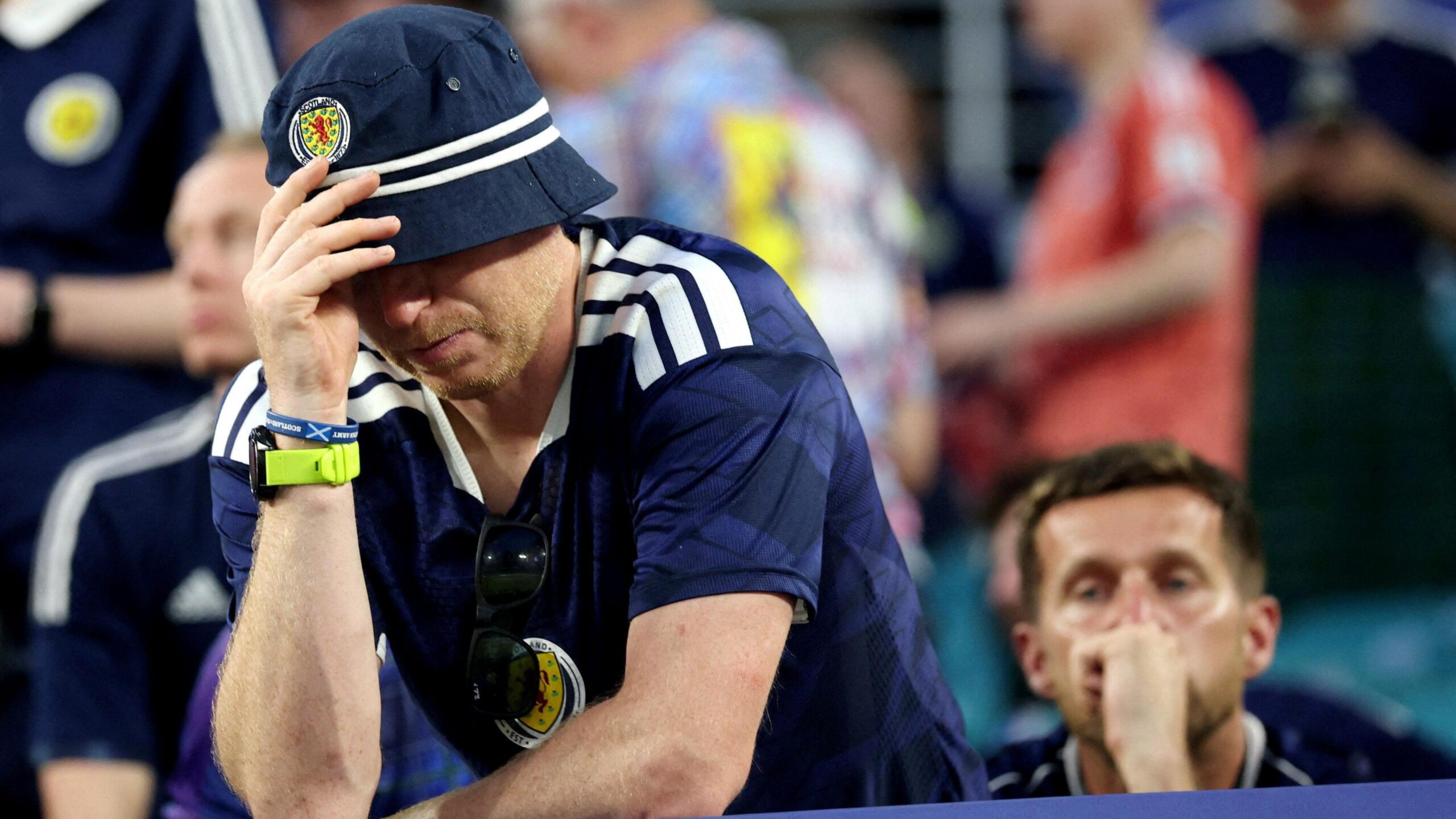 A dejected Scotland fan wearing a bucket hat and a Scotland home top, pictured after the Brazil defeat
