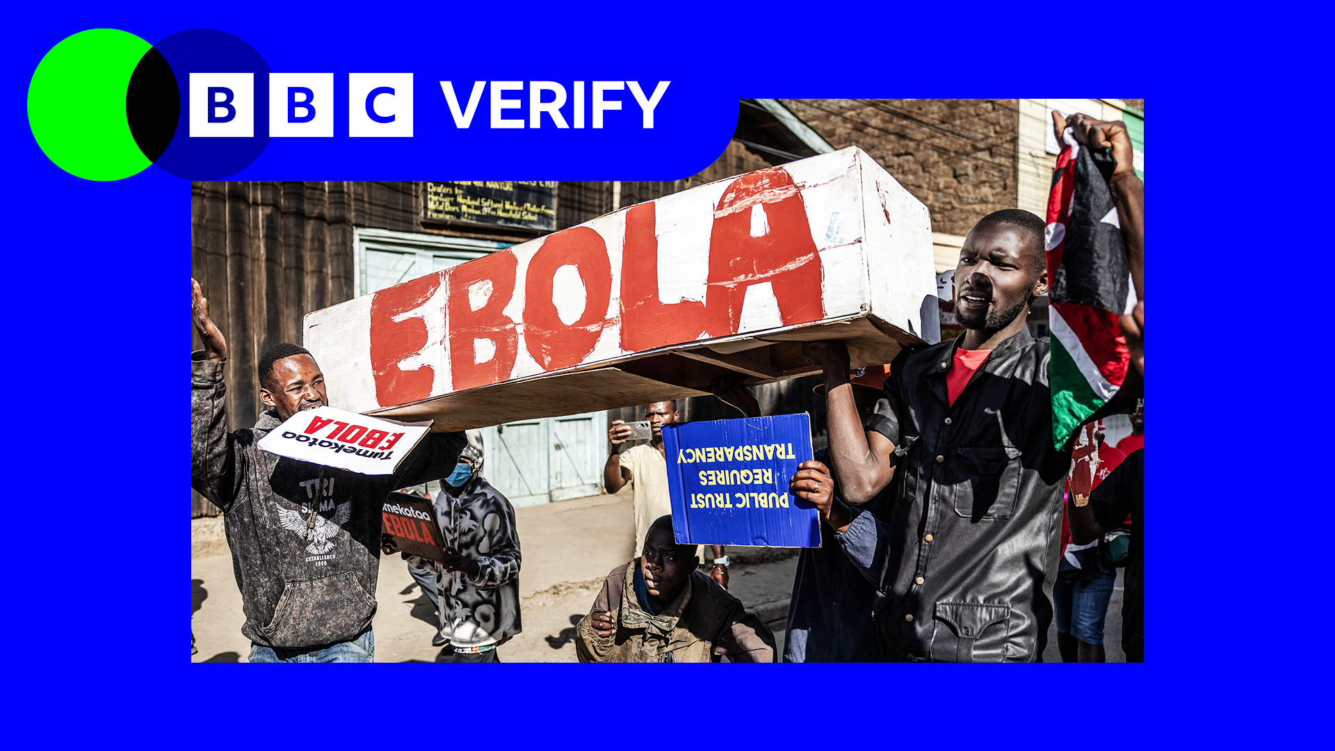 Protesters march during a demonstration against a controversial US-built Ebola quarantine centre. There is blue and green BBC Verify branding in the top left.
