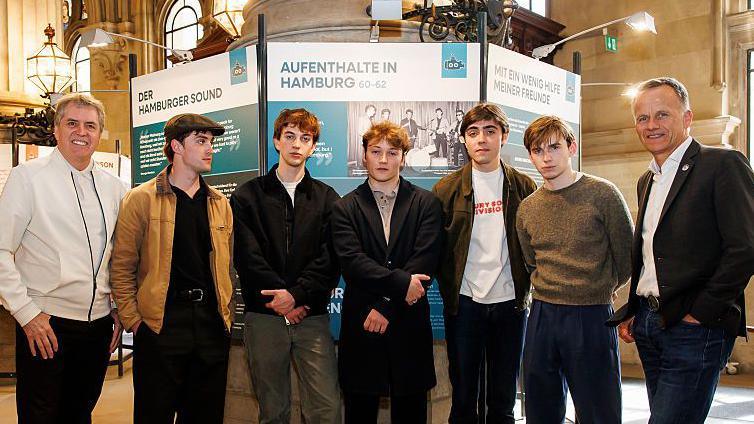 Steve Rotheram, actors Rhys Mannion, actor Harvey Brett, actor Patrick Gilmore, actor and musician Ellis Murphy, actor Louis Landau and Hamburg's State Secretary of the Ministry of the Interior and Sports, Christoph Holstein pose for a photo during the opening of the exhibition "Hafenstaedte. Schaupaetze der Welt" at Hamburg City Hall