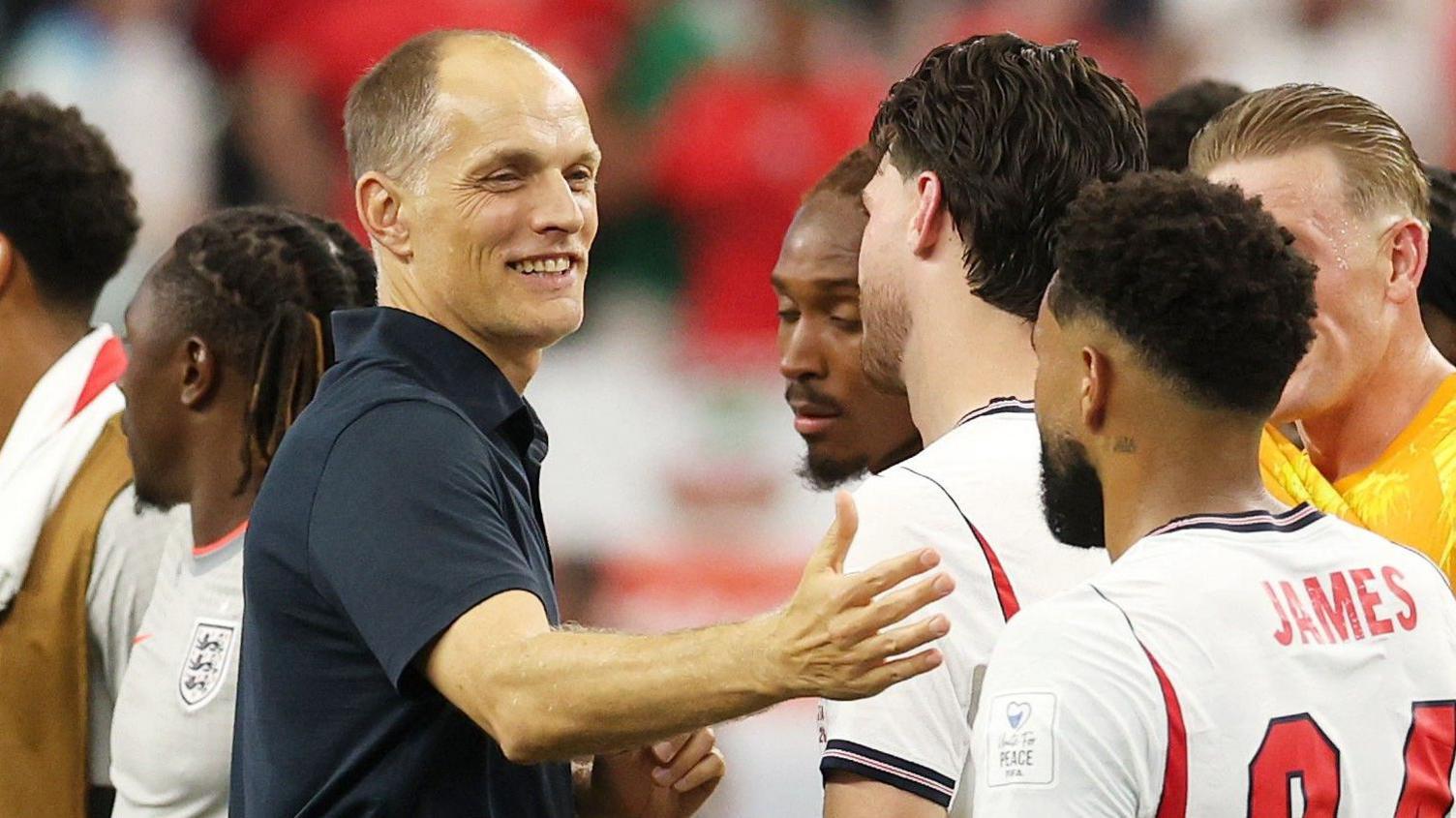 Thomas Tuchel embraces a group of England players