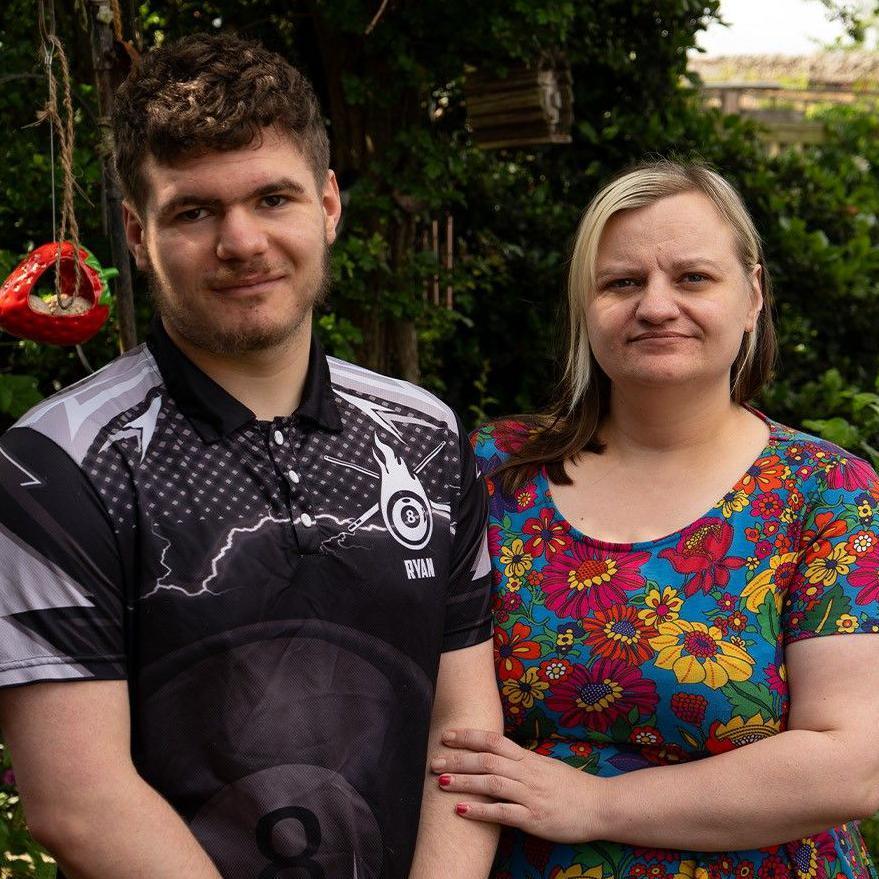 Ryan and Sarah stand side by side in a garden
