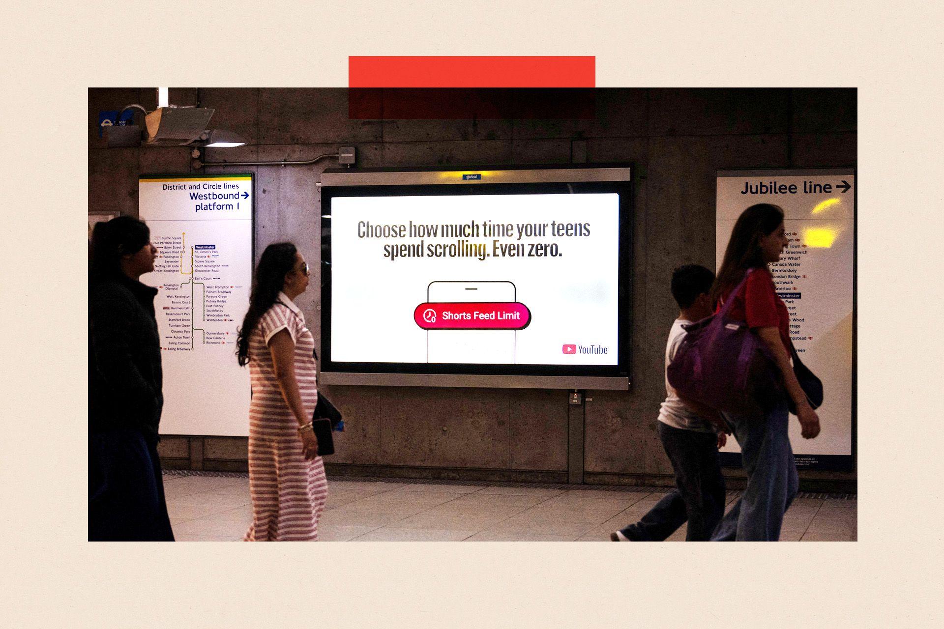 A YouTube advert at Westminster Underground station in London reads: "Choose how much time your teens spend scrolling. Even zero." Below that is the outline of a mobile phone and an image of a red notification that reads: "Shorts feed limit" alongside an icon of a clock. The YouTube logo is also visible on the advert. Strolling past are three women and a boy.  Maps of the westbound District and Circle lines and the Jubilee line are also visible.