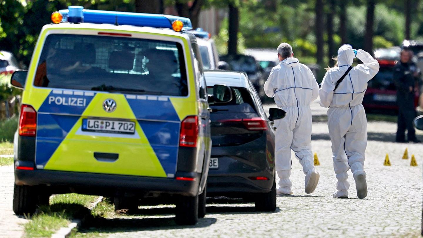 Crowds of emergency workers stand in the road following a shooting in Stade, northern Germany.