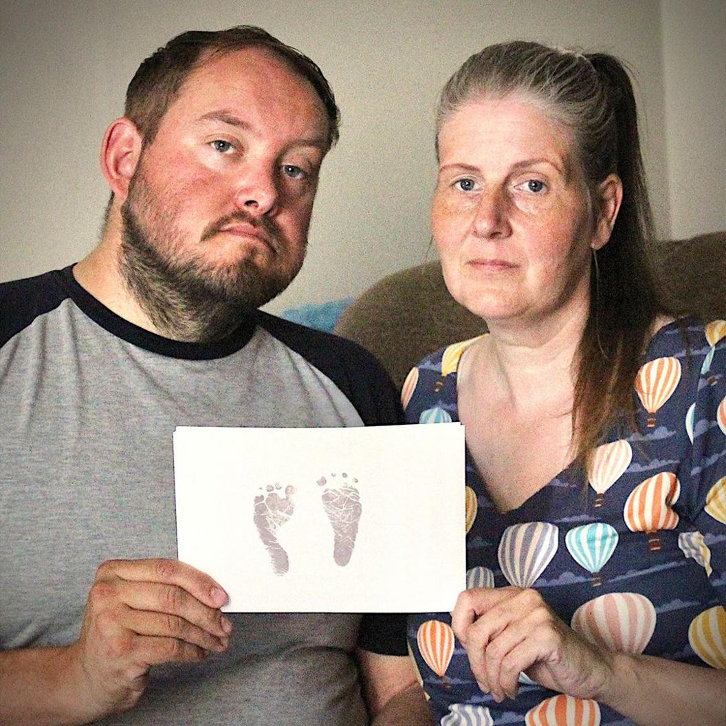 Sarah and Gary Andrews hold up their daughter's footprints.
