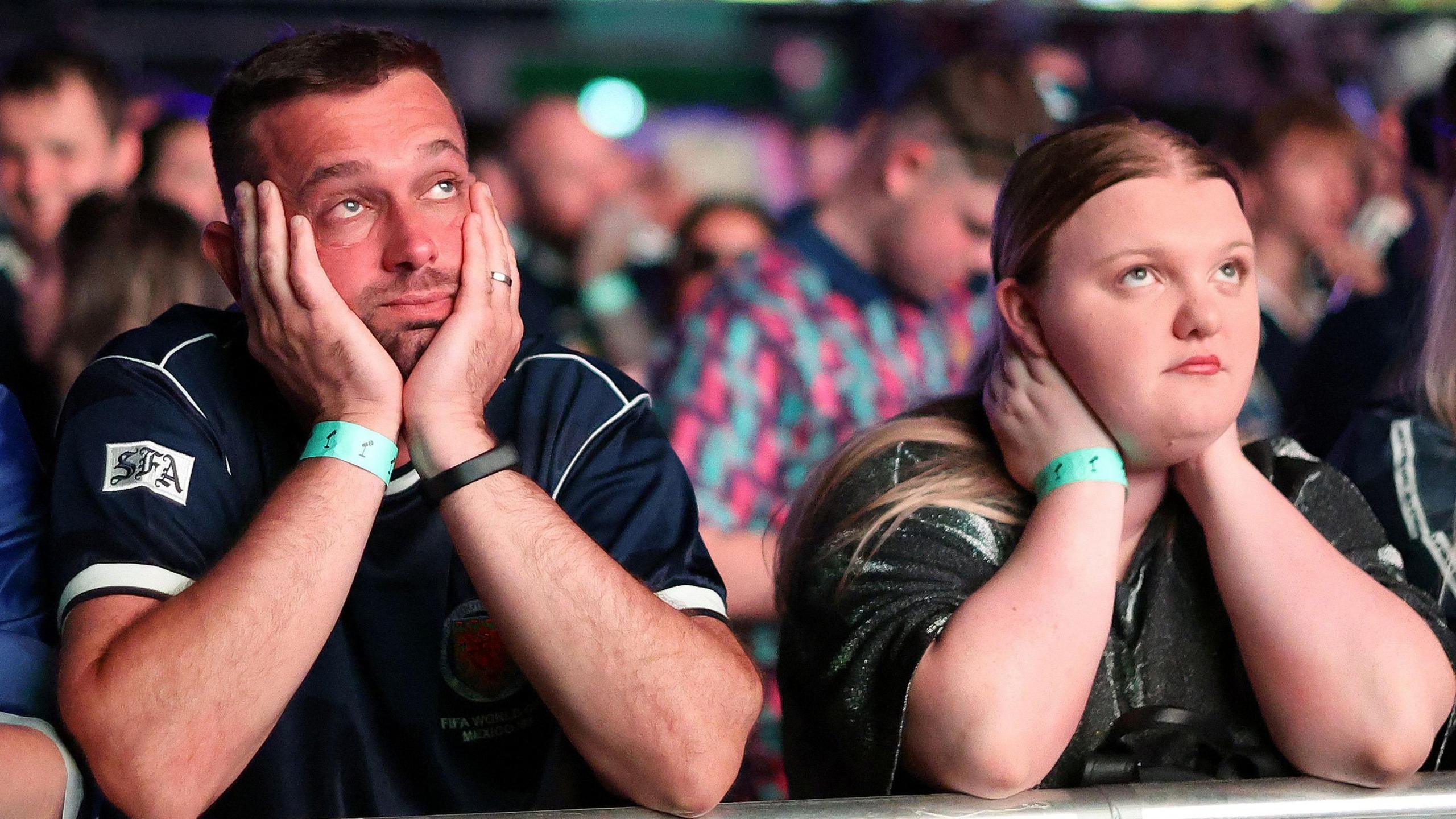 Glum Scotland fans watching the Brazil match on a giant screen
