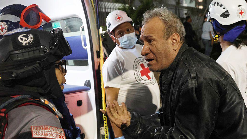 A man speaks to a paramedic in a demolished building at Los Palos Grandes after a magnitude 7.2 earthquake struck Venezuela and other regions in the Caribbean on June 24, 2026 in Caracas, Venezuela.