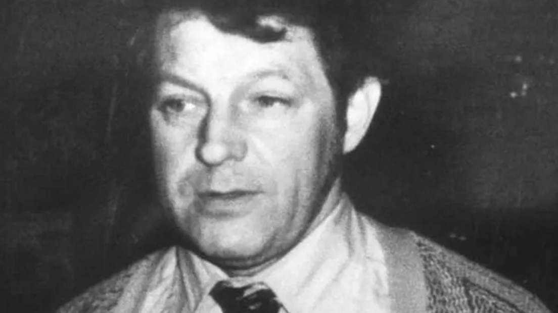 A black and white photo of a man in a suit
