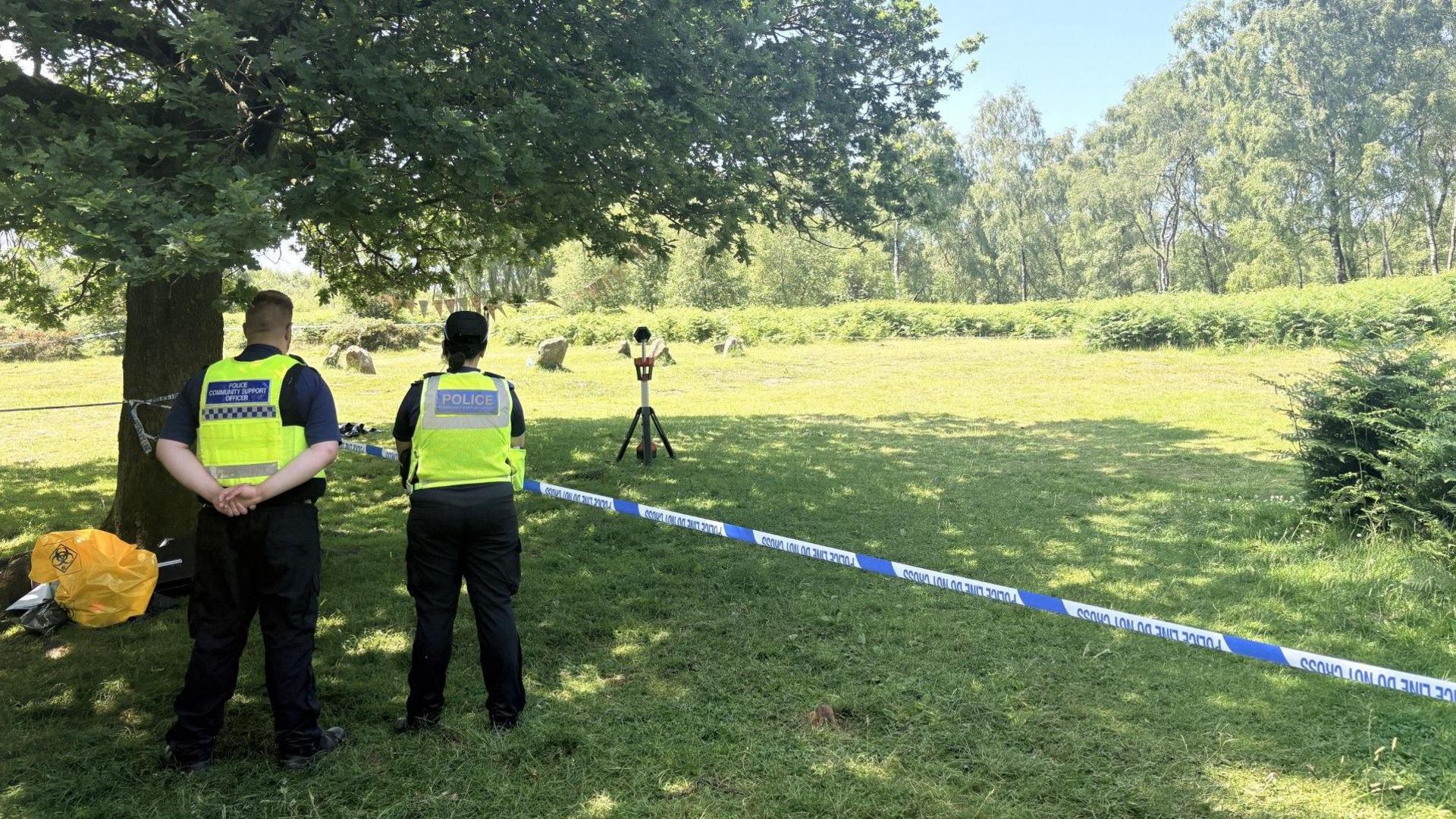 Police cordon with officers facing away from the camera