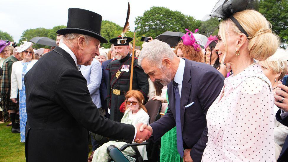 Graeme Souness shaking hands with the King and bowing.