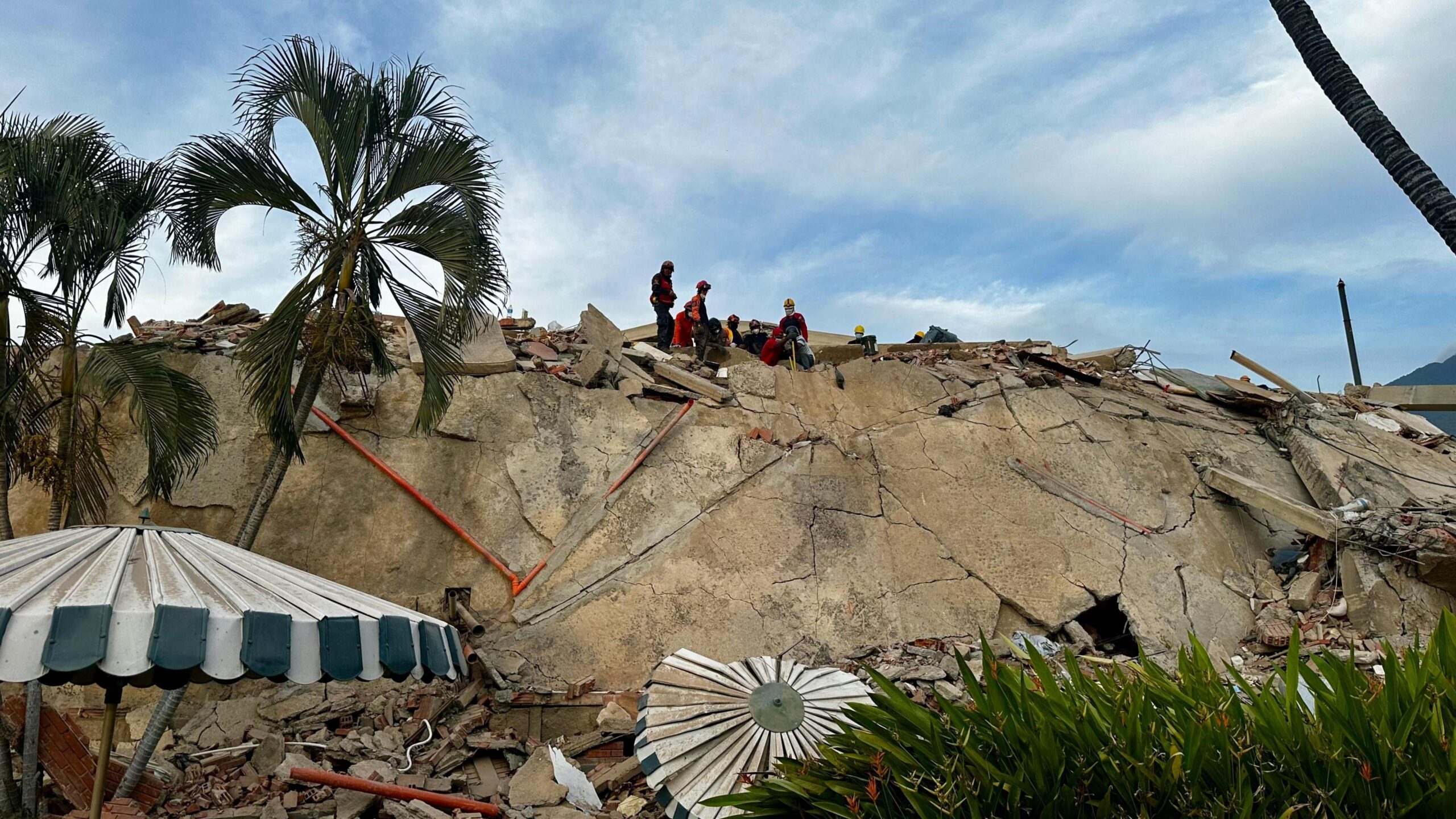 Debris piles up at the Caribe residential complex in the Caraballeda parish, La Guaira state. A small group of rescuers can be seen at the top the pile of rubble.