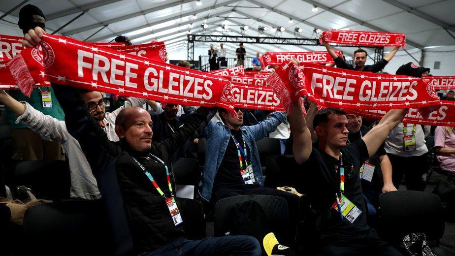 Journalists hold up scarves reading 'Free Gleizes' in support of French sports journalist Christophe Gleizes before the the start of the France press conference at New Jersey New York Stadium