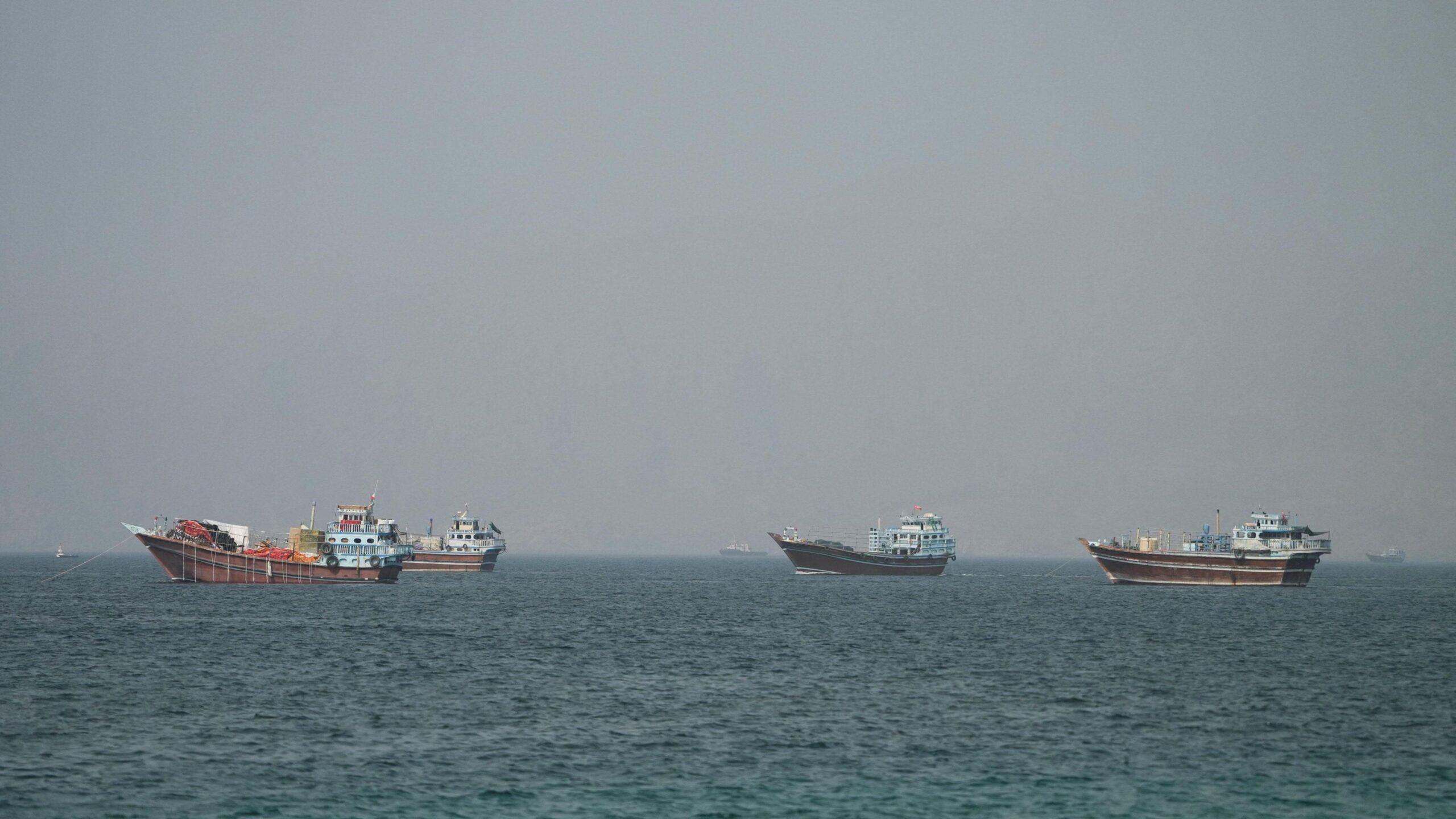Four large boats drifting on the Strait of Hormuz as seen from Oman.