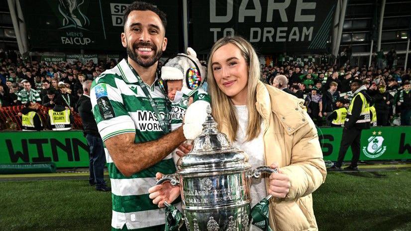 Roberto Lopes of Shamrock Rovers celebrates with his wife Leah and son Diego after helping his side win the FAI Cup in 2025