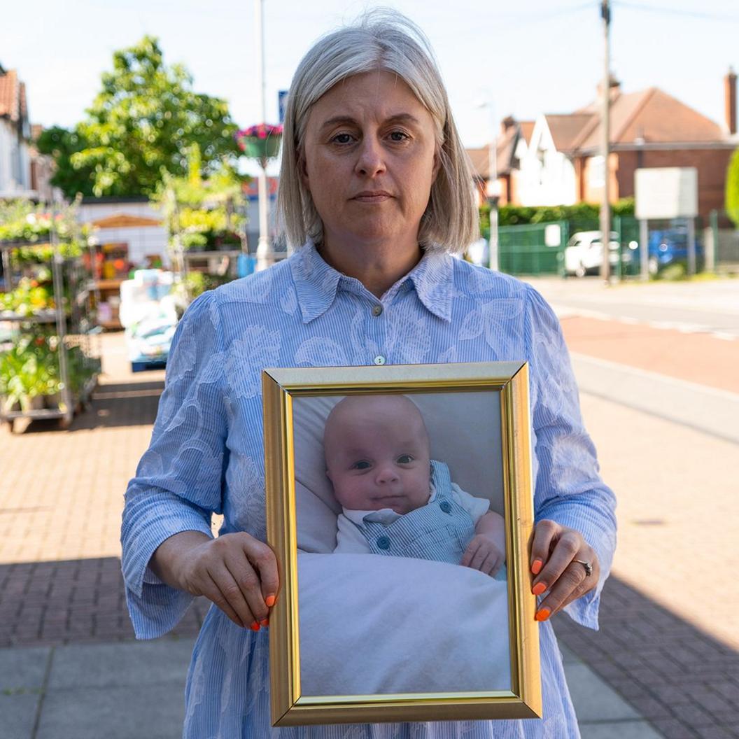 Michelle Welsh holds a framed picture of her son