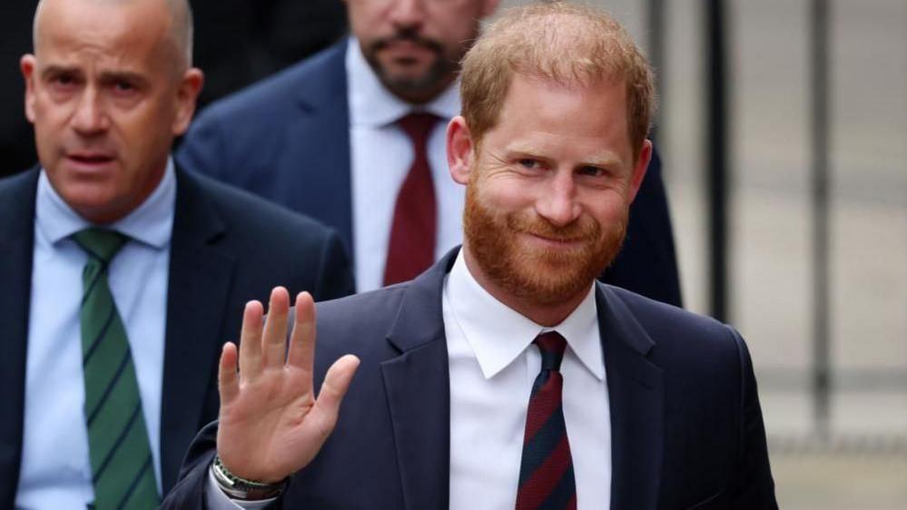 Prince Harry smiles and waves
