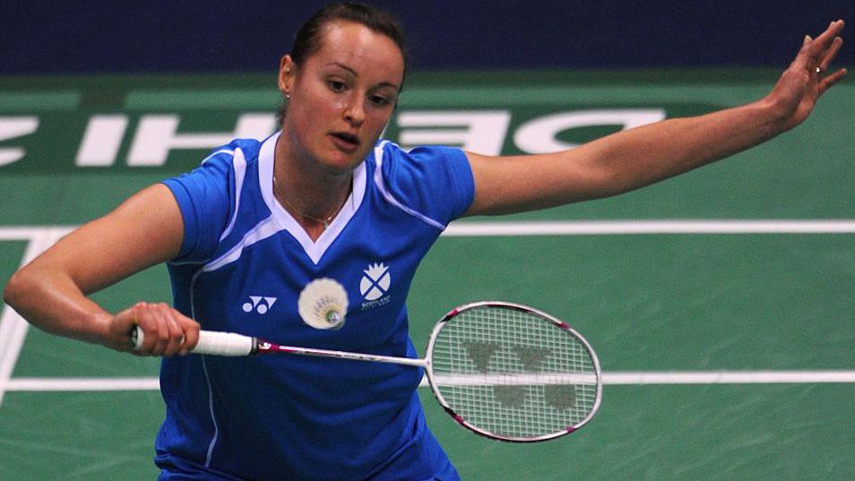 A woman playing badminton, wearing blue and white as she is representing Scotland.