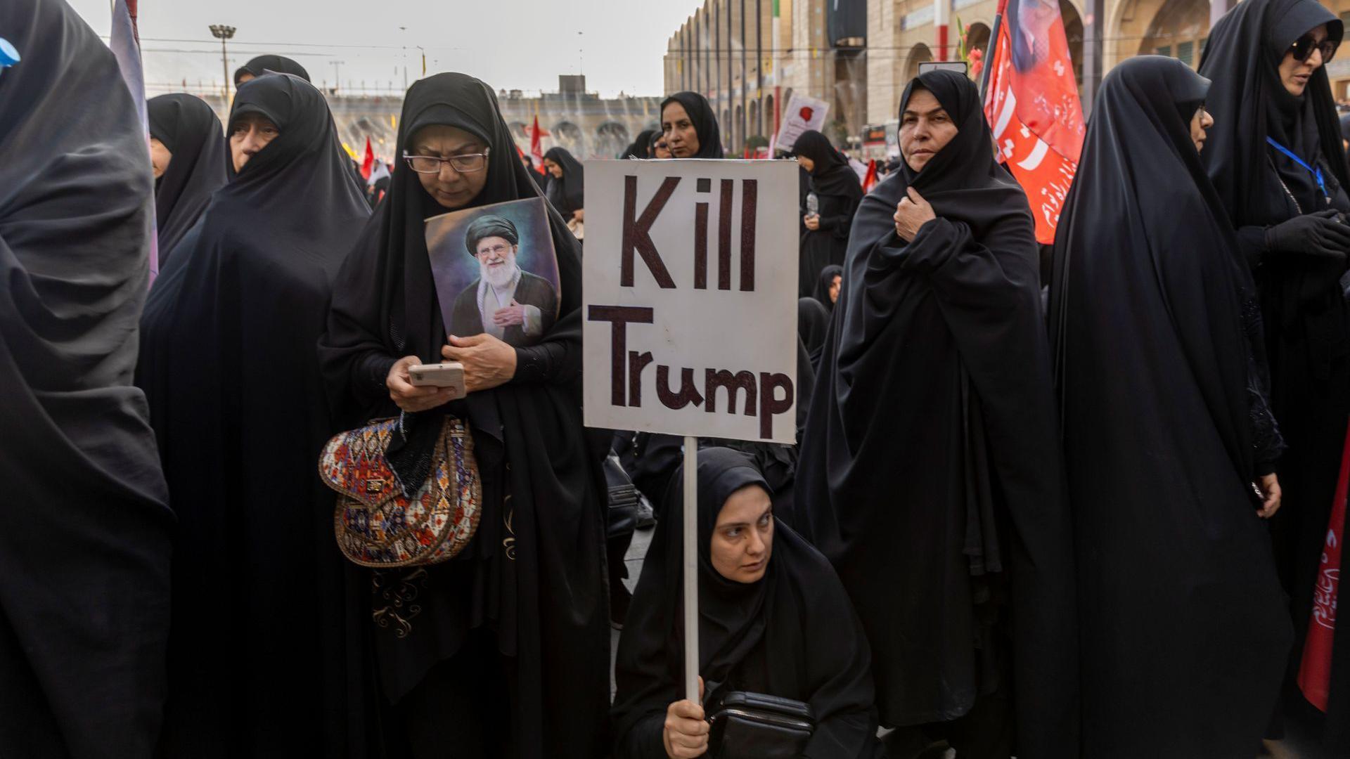 A women holding a "kill Trump" sign