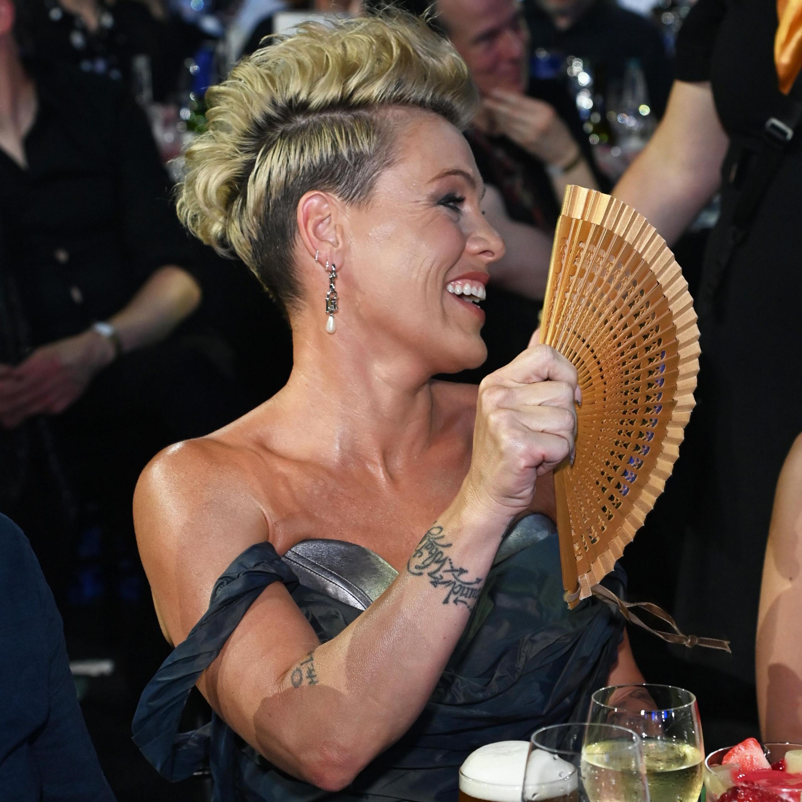 Pink fans herself while seated at the Silver Clef Awards