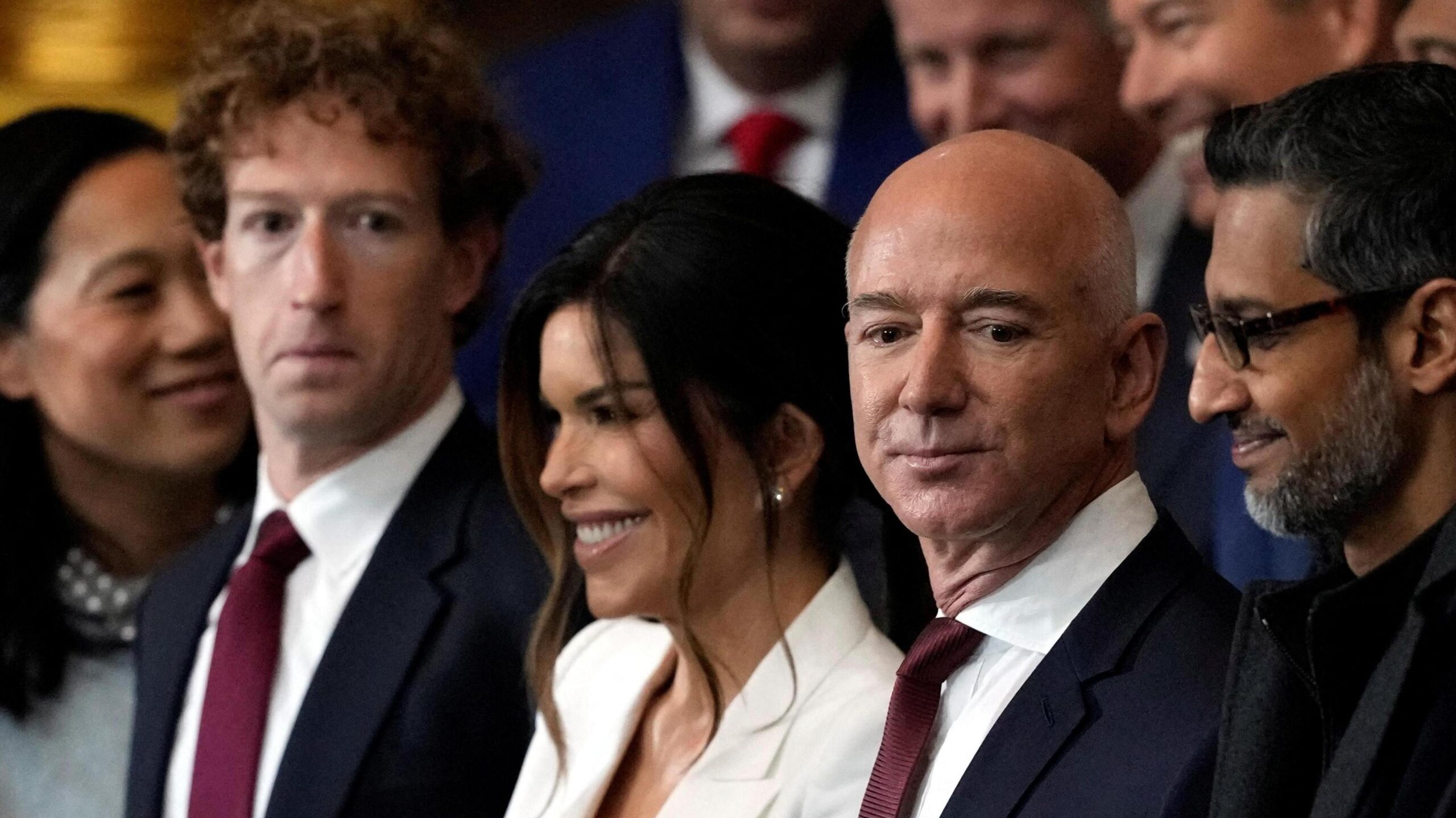 Meta CEO Mark Zuckerberg stands in a crowd next to amazon Chairman Jeff Bezos and Google CEO Sundar Pichai.