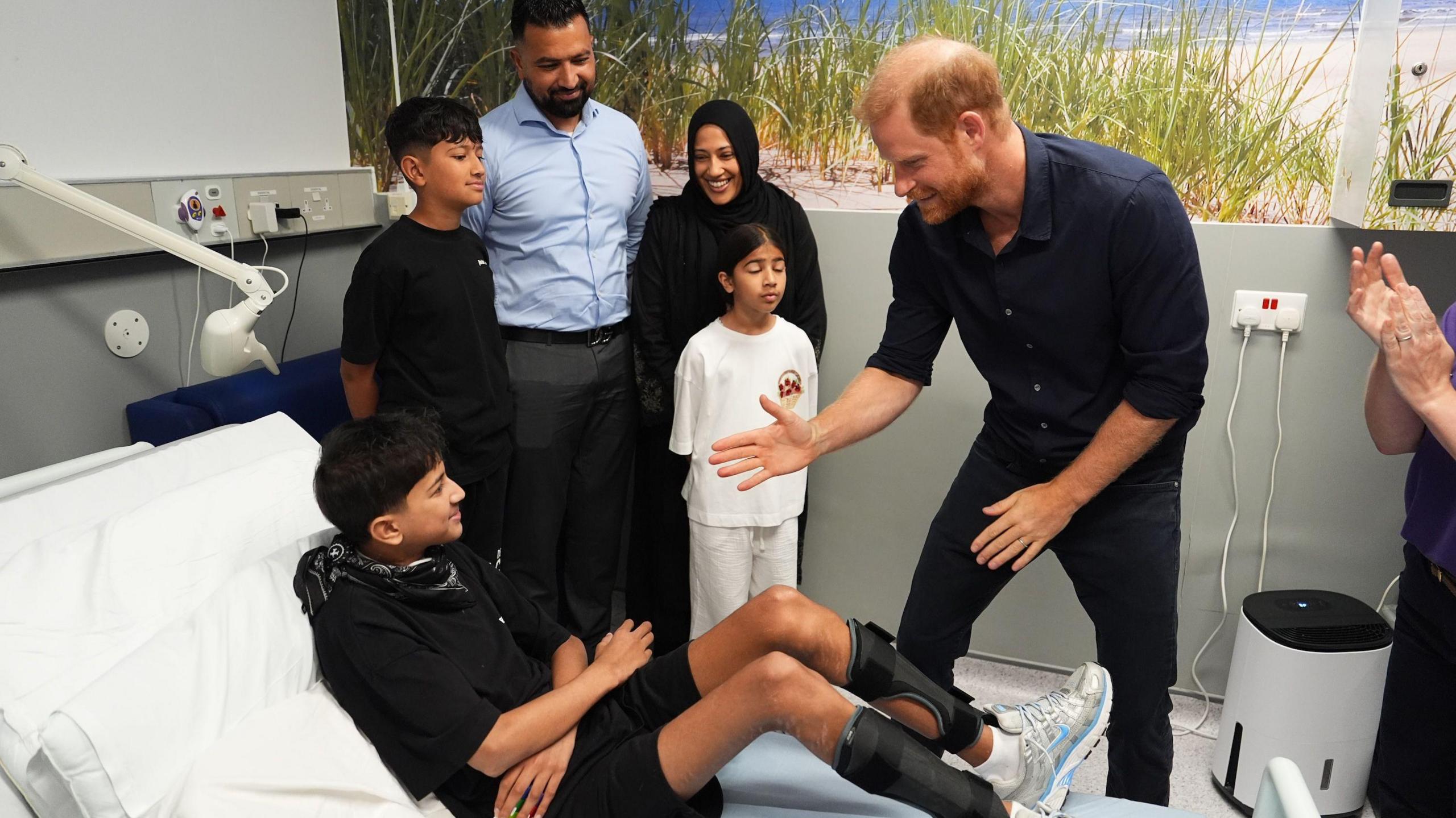 Prince Harry meets a young patient on a visit to support the WellChild charity