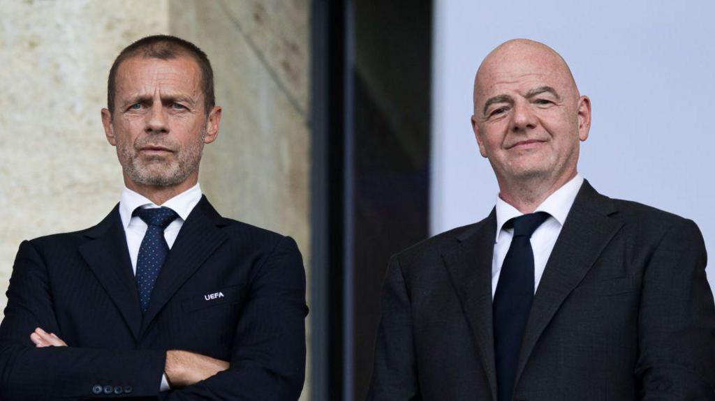 Uefa president Aleksander Ceferin and Fifa president Gianni Infantino look o from the stands during a football match