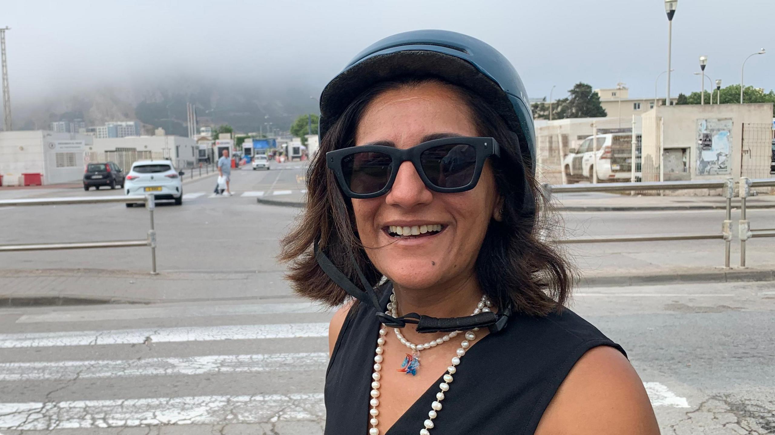 Spanish woman Shilpi Chotrani who every working day travels across the border by motorbike to work in Gibraltar. She is wearing a helmet and sunglasses.