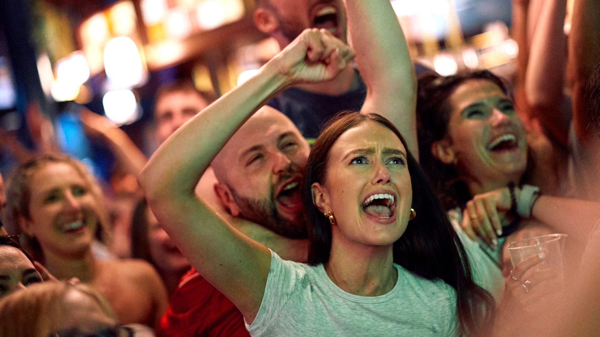 England fans celebrate their team's goal as they watch a live screening of the UEFA Euro 2024 final football match between Spain and England being played in Berlin, inside a pub in central London on July 14, 2024.