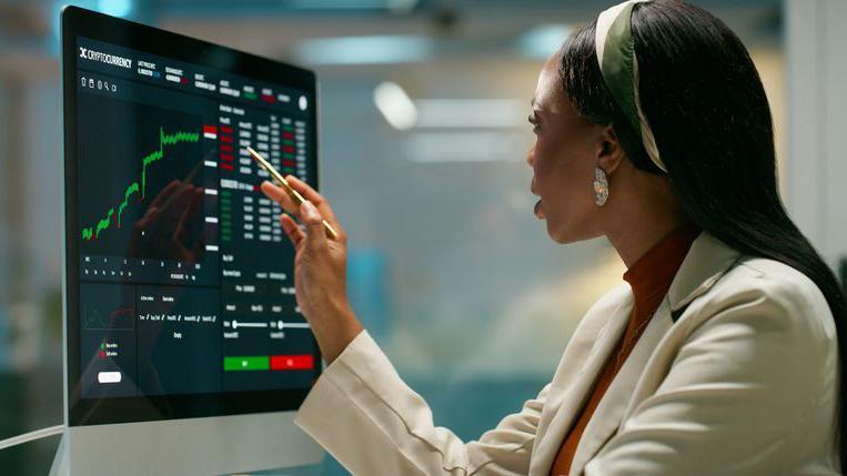 Woman pointing at computer screen with a chart on it