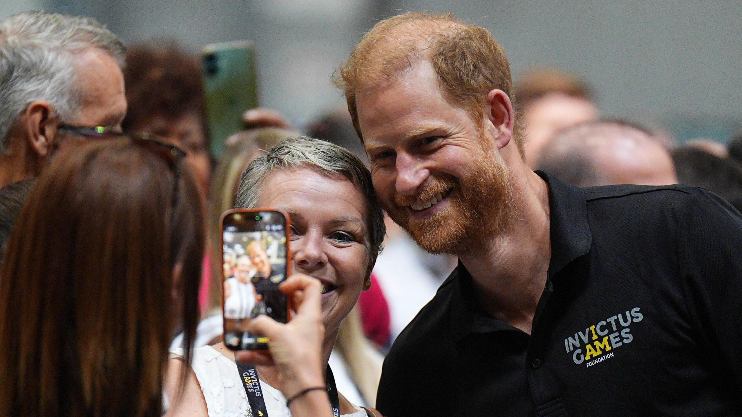 Prince Harry has is photo taken with a woman.