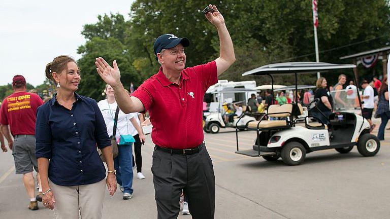 Nordone (left) seen at the Iowa state fair in 2015 with her older brother. She wears a blue shirt and he wears a red shirt and blue hat. There is a golf cart near them