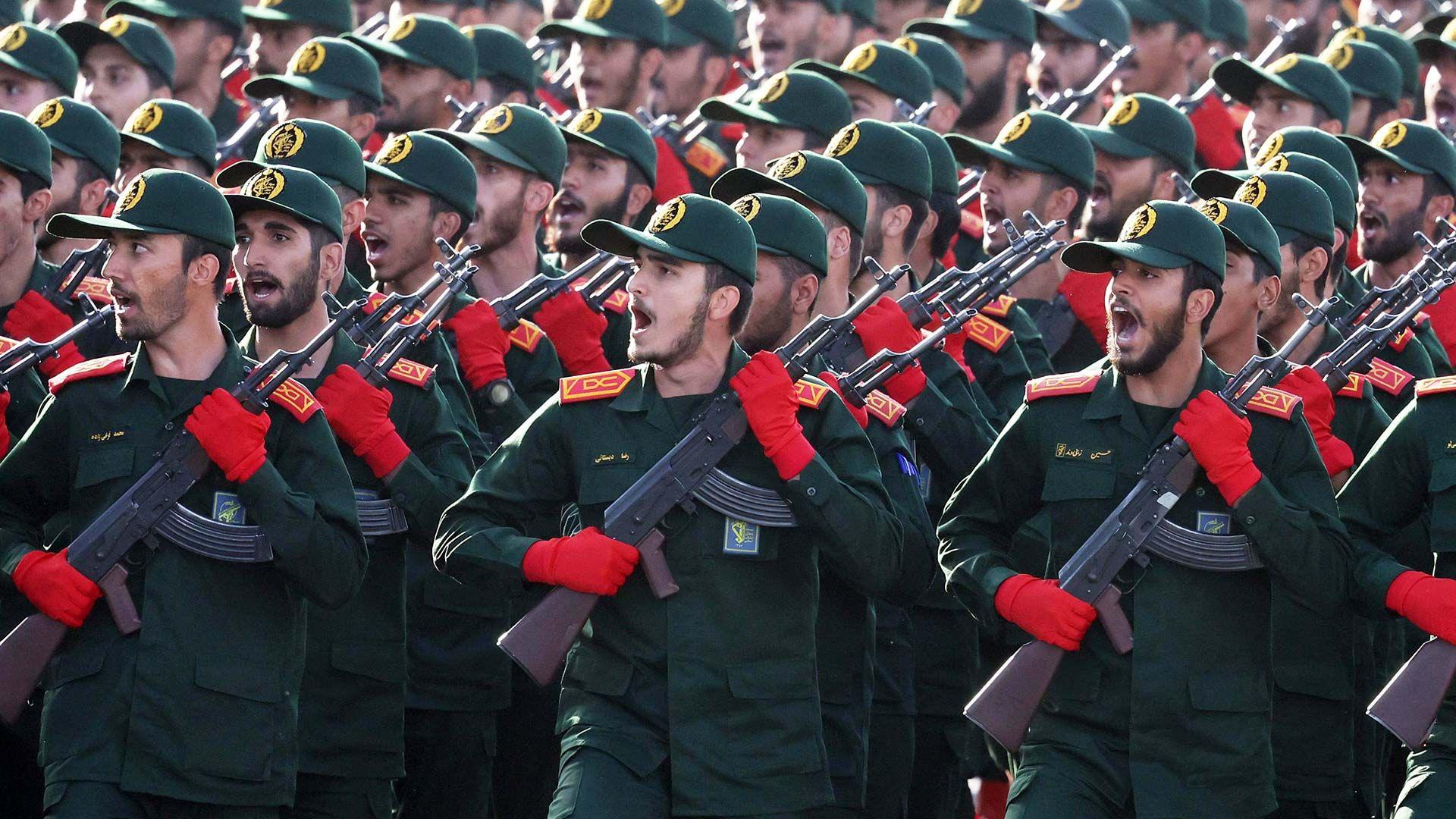 A picture of soldiers in a dark green uniform and red gloves.
